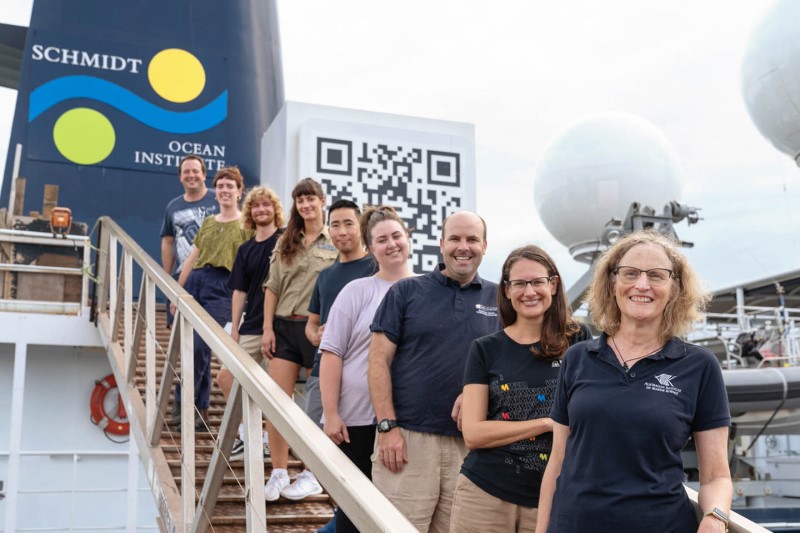 Crew and scientists stand in a line on the ship RV Falkor's ramp