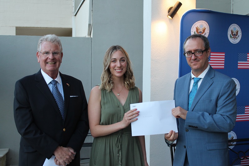 Woman receiving scholarship award with Fulbright representatives