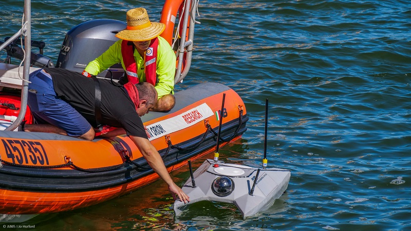 an autonomous vehicle is launched by men in a small boat 