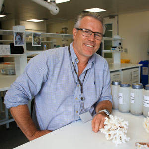 man in blue shirt at lab bench with coral