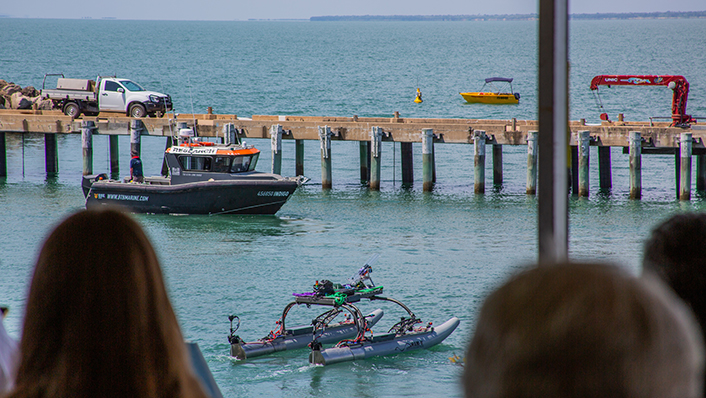 Autonomous Vessel on the water with an audience on shore