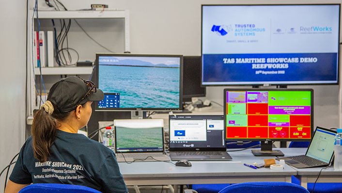 A person sits at multiple computer screens