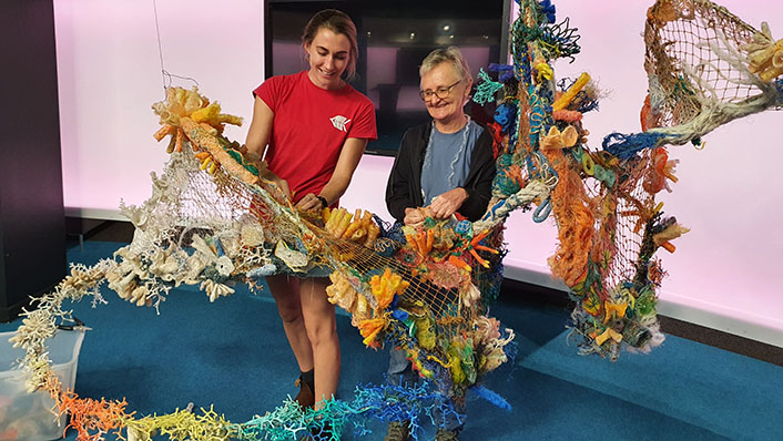 AIMS staff and artist create a large art installation