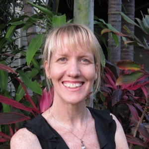 Woman with blonde hair standing Infront of pink and green plants