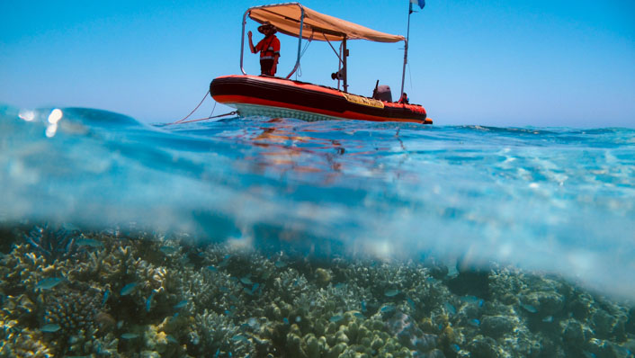 a small boat is moored on a reef