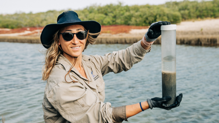 Woman holds a tube of water and sediment