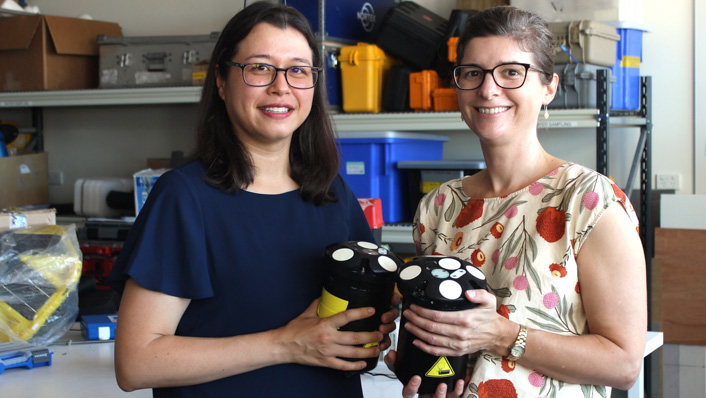 two women hold sensors that measure ocean currents