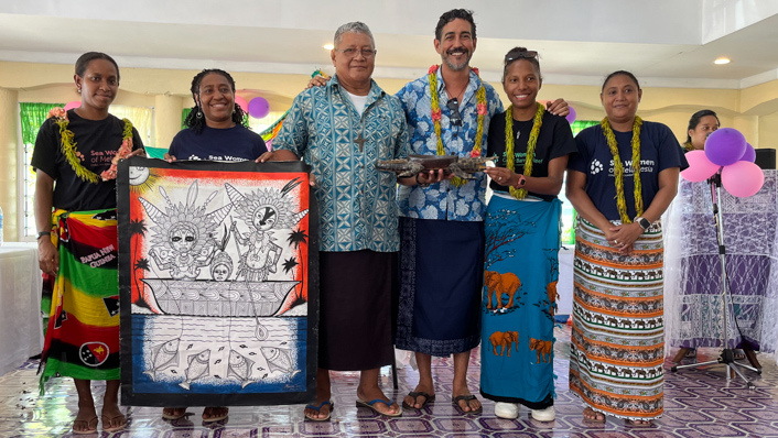 a group of people in Samoan traditional dress with posters