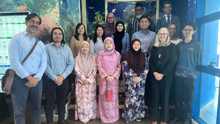a group of people from different backgrounds standing together and smiling at the camera