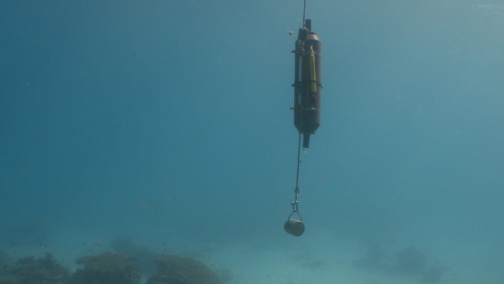 Niskin bottle lowered into tropical ocean