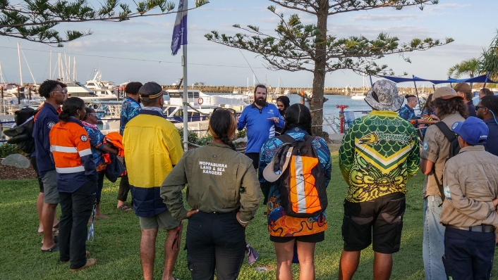 Indigenous Rangers standing in a circle for a briefing