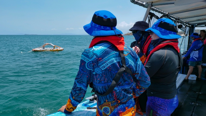 Scientists and Indigenous Rangers look out to sea at an inflatable coral larval pool
