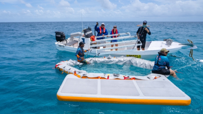 Scientists setting up inflatable pool from boats in tropical seas