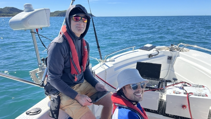Engineers on boat posing next to reef monitoring equipment
