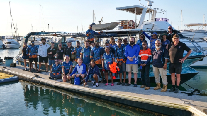 Group shot of researchers on a jetty by a boat