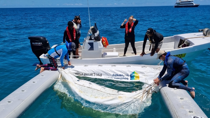 Scientists assembling inflatable pool on the ocean