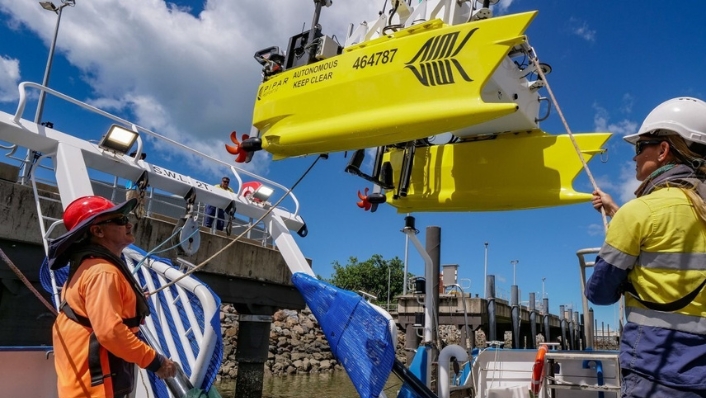 Reefcat autonomous surface vehicle being lifted onto a research ship