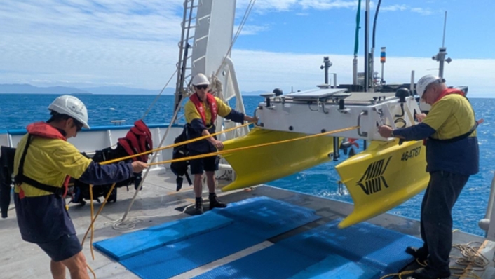 ReefCat autonomous surface vessel being lifted onto a research vessel