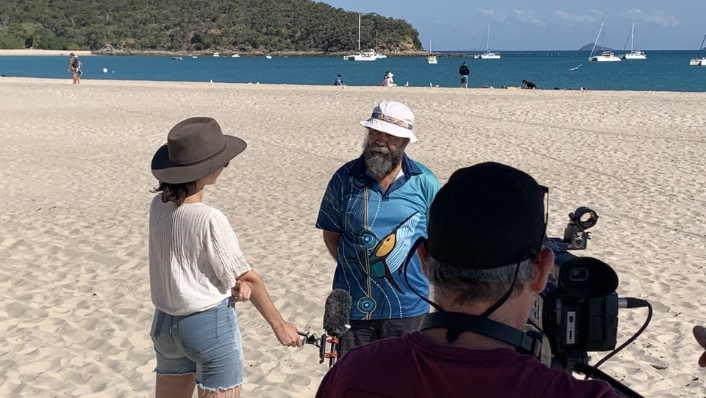 Bob Muir being interview by media on a beach