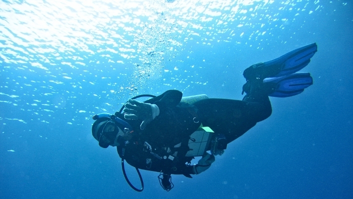 SCUBA diver descending with surface above