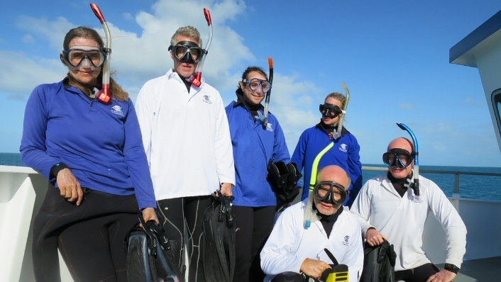 Marine scientists on ship deck wearing snorkels comically