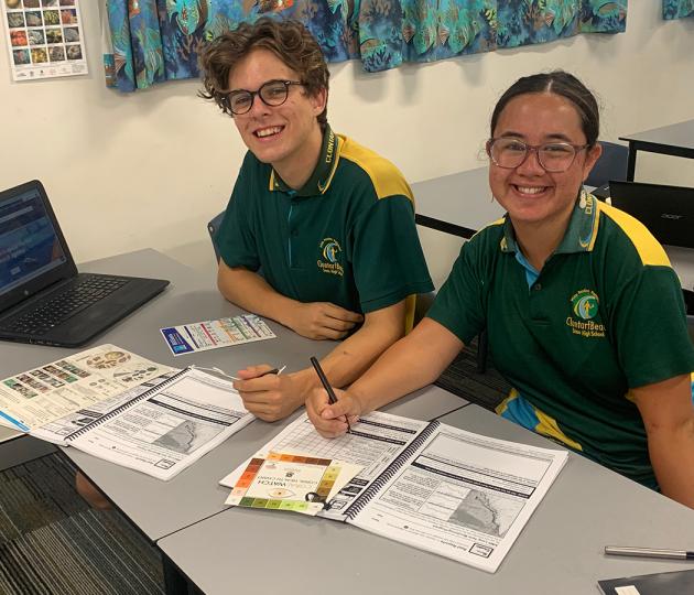 two students happy about working with marine science workbook