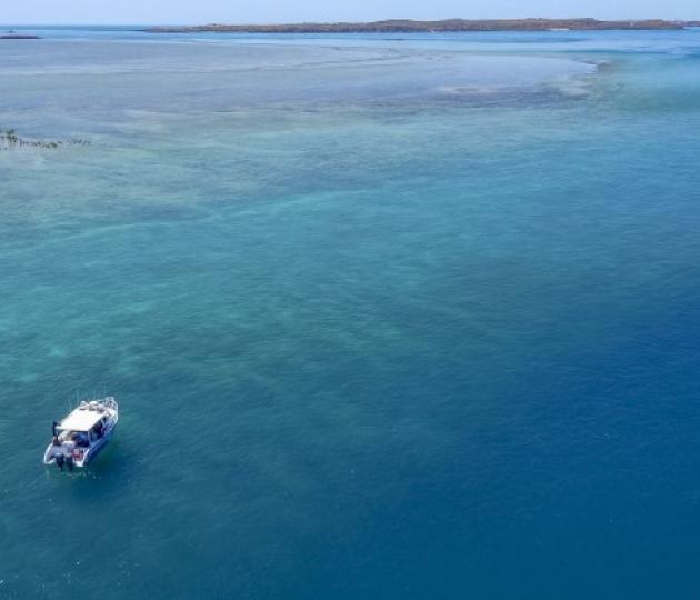 aerial photo of vessel near a reef