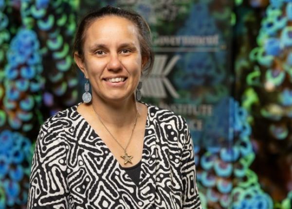 A potriat image of a woman smiling at the camera with a colourful background