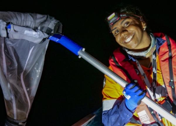 Indigenous Ranger with net at sea at night