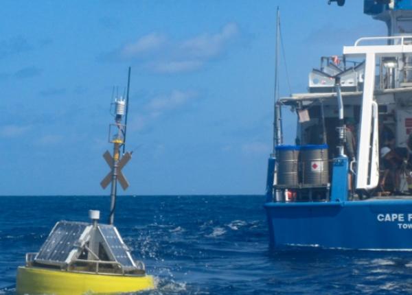 Ocean monitoring buoy with research vessel.