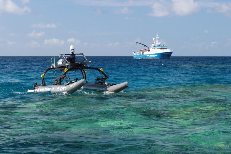 Robot on surface of water with AIMS vessel in background
