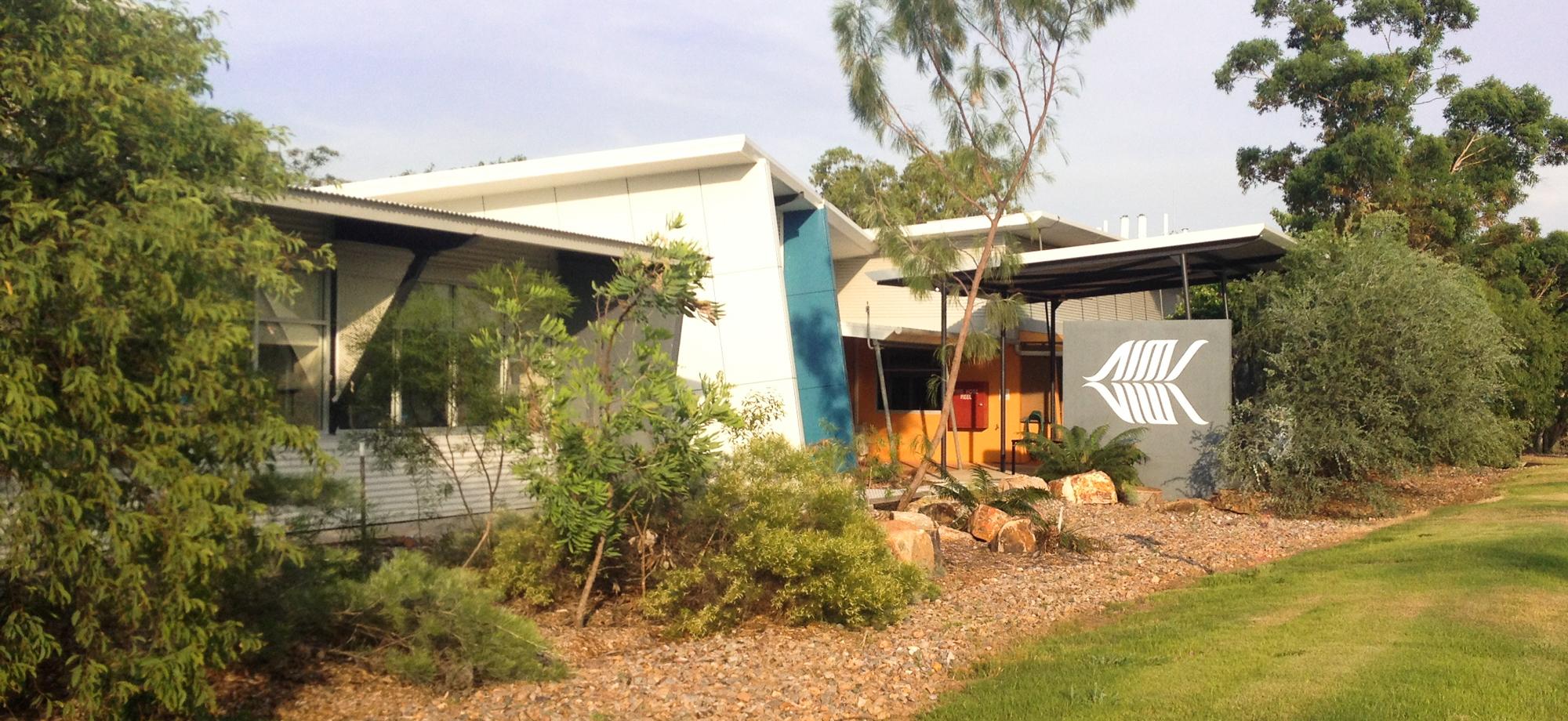 a building with an AIMS logo behind native garden beds