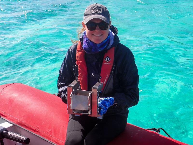 Female holds engineering device on small boat