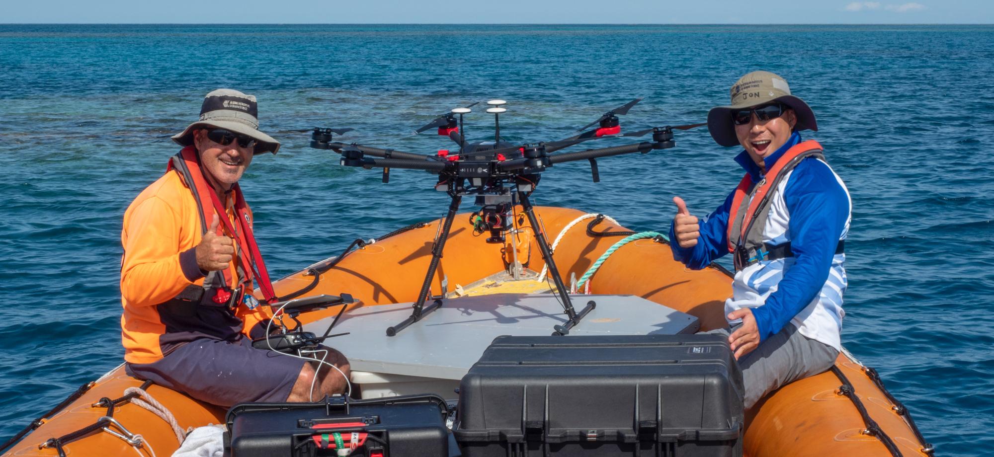 people in orange boat with a large drone