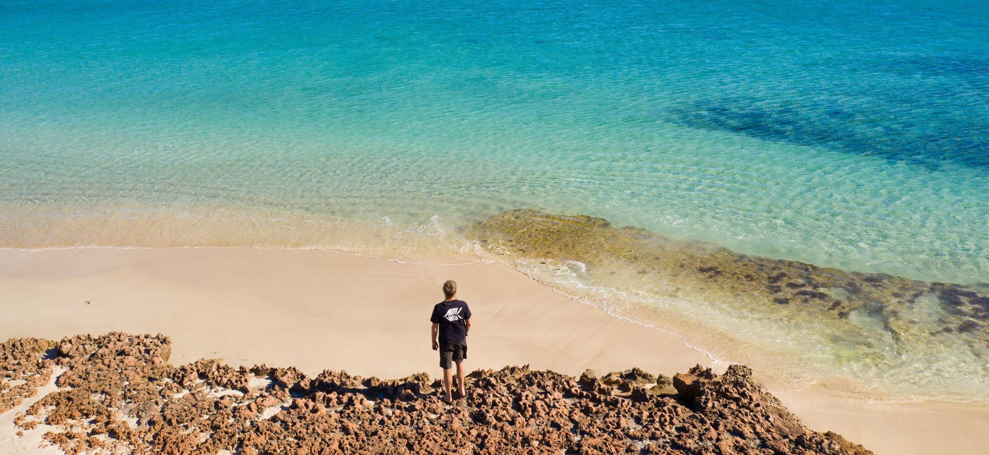 person on edge of water with very yellow and but turquoise water