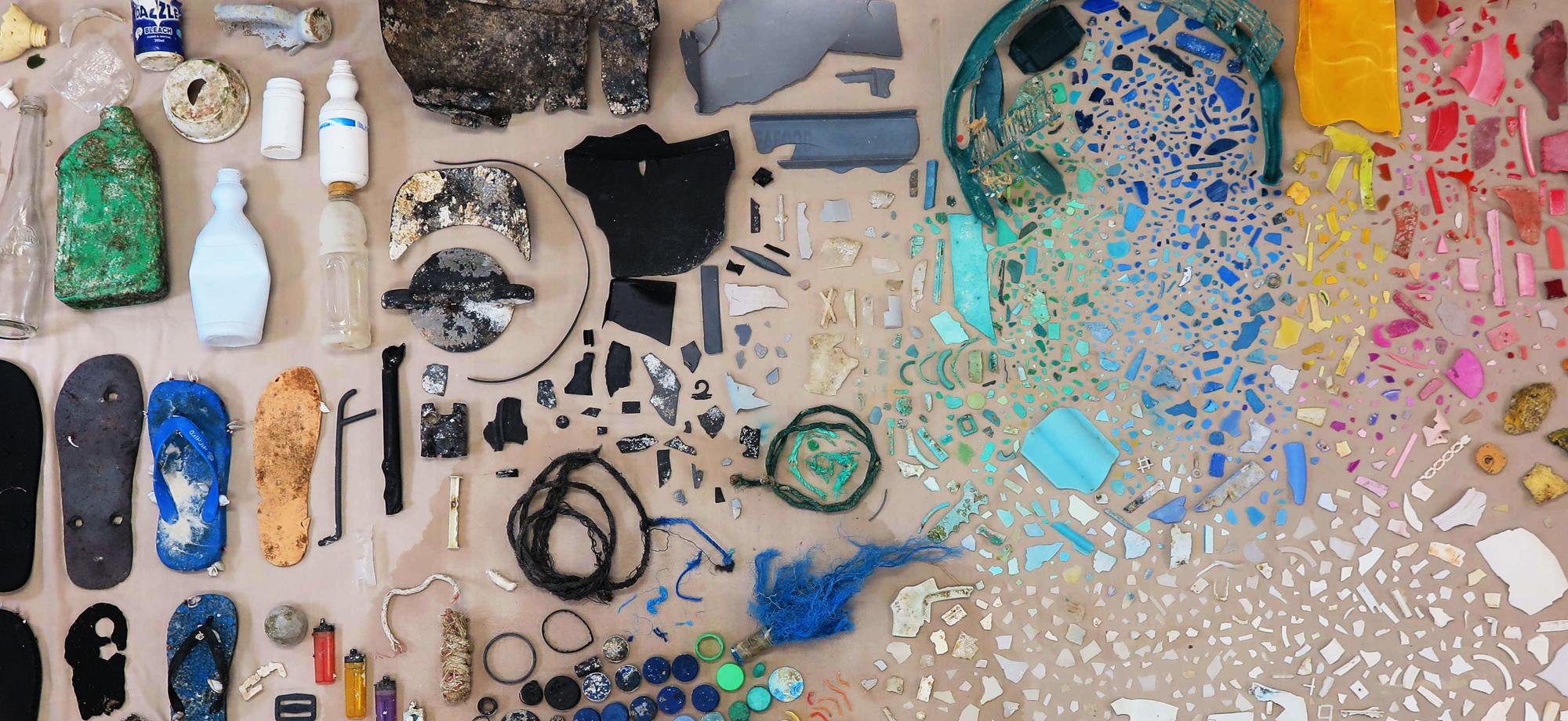 a range of pieces of plastics arranged artistically on the beach
