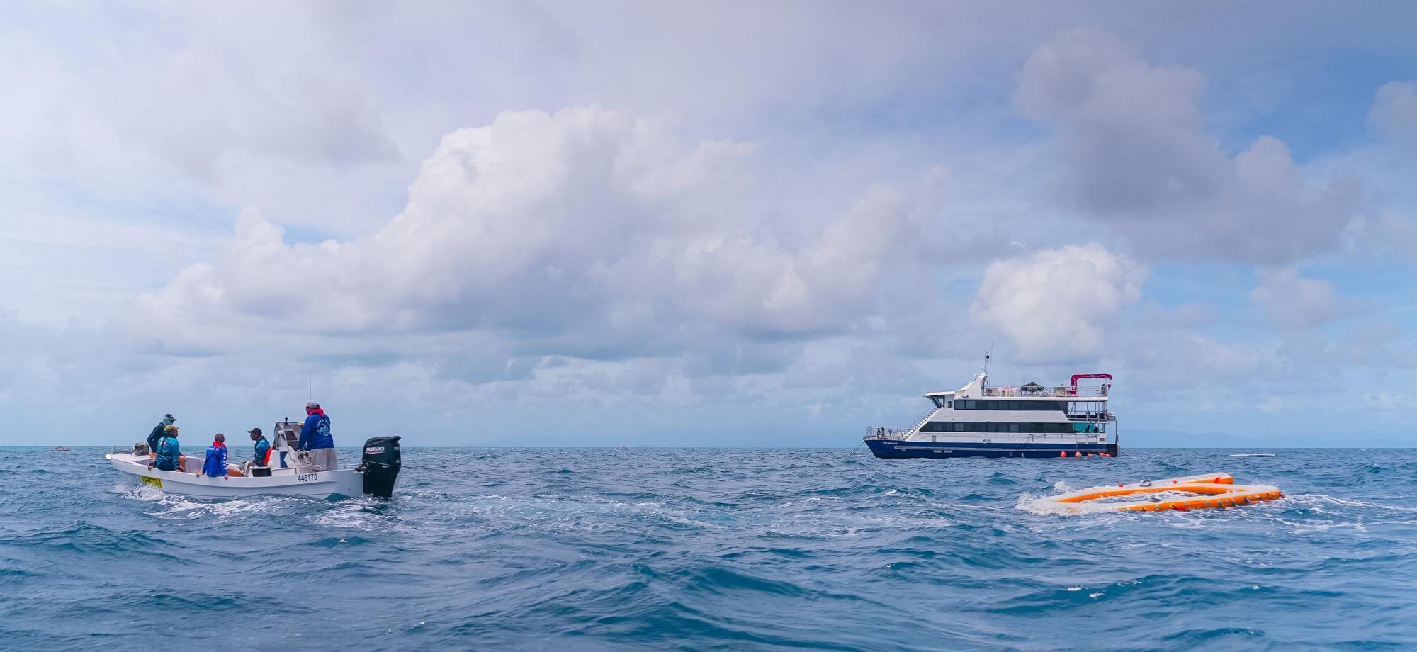 Scientists on boat setting up inflatable pool on the ocean