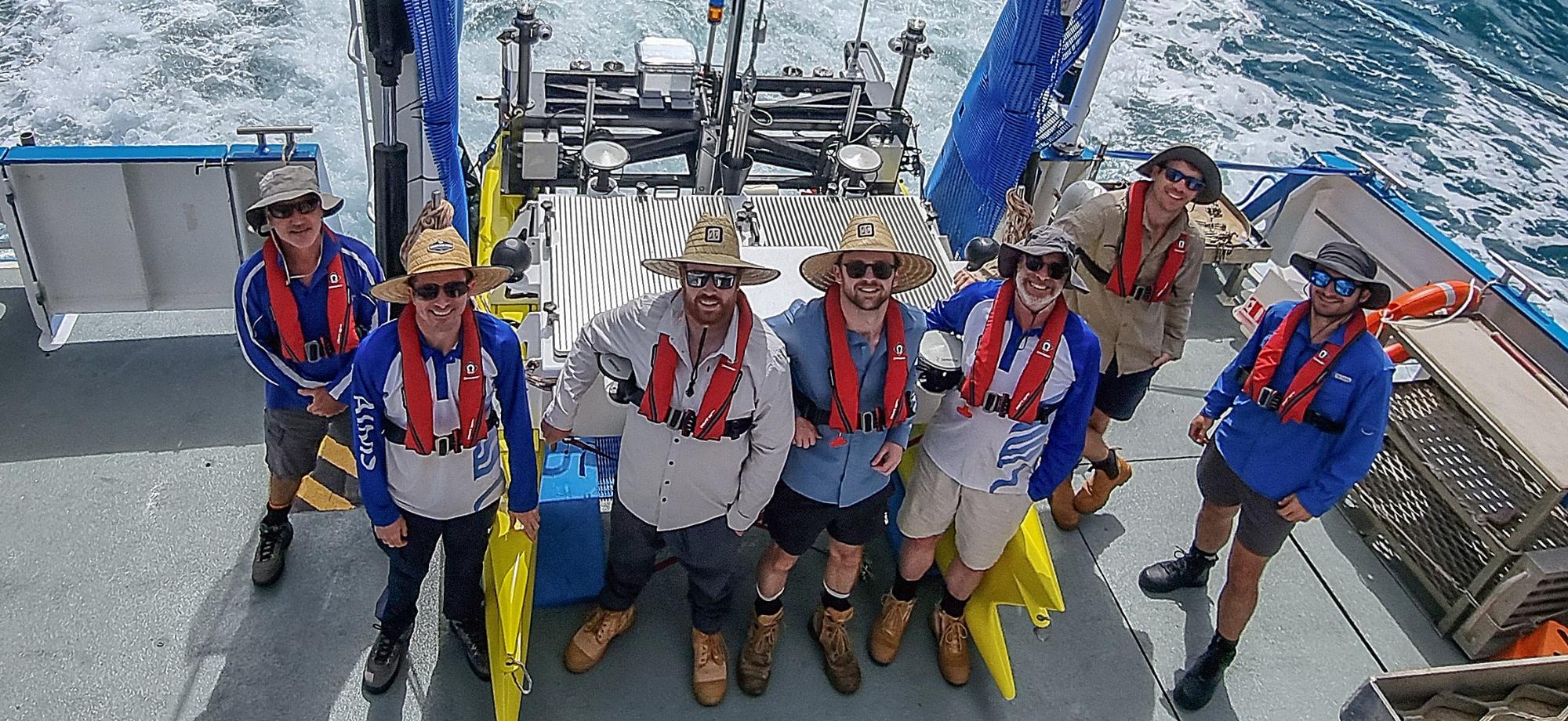 Team of marine engineers around the ReefCat autonomous surface vessel