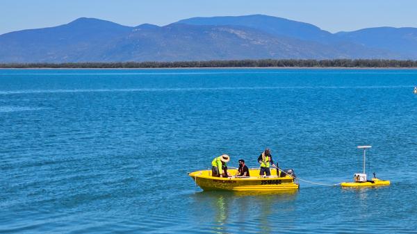 small research vessel tows a surfboard setup with autonomous systems