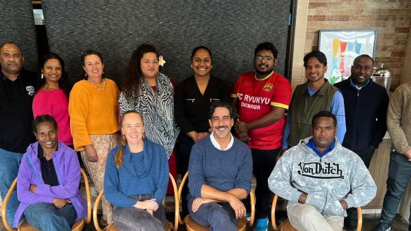 People posing for a group photo in a classroom
