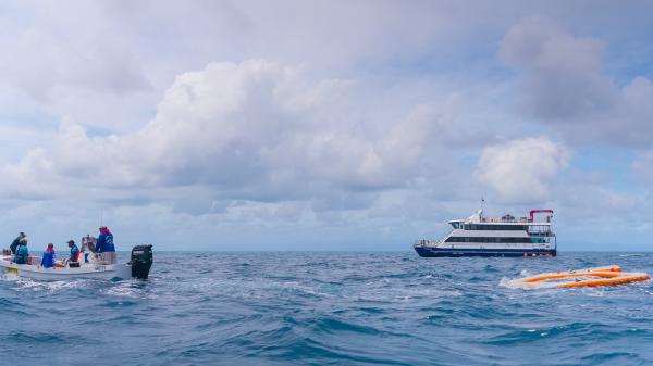 Scientists on boat setting up inflatable pool on the ocean