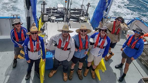 Team of marine engineers around the ReefCat autonomous surface vessel
