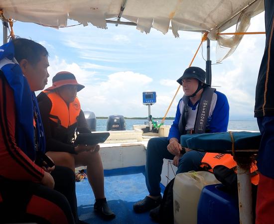 people sit on a small vessel with a reefscan attached to the back of the vessel