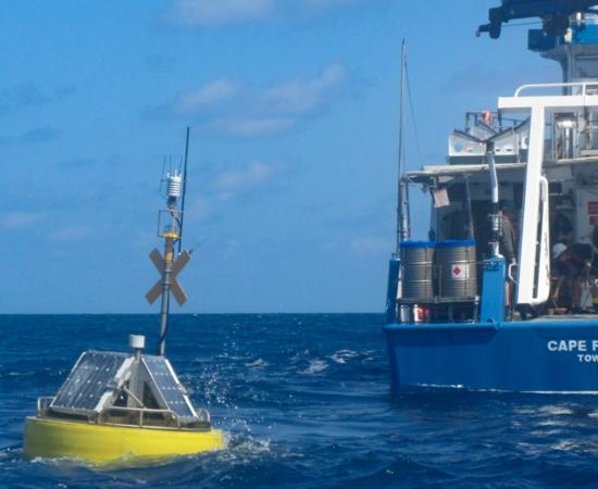 Ocean monitoring buoy with research vessel.